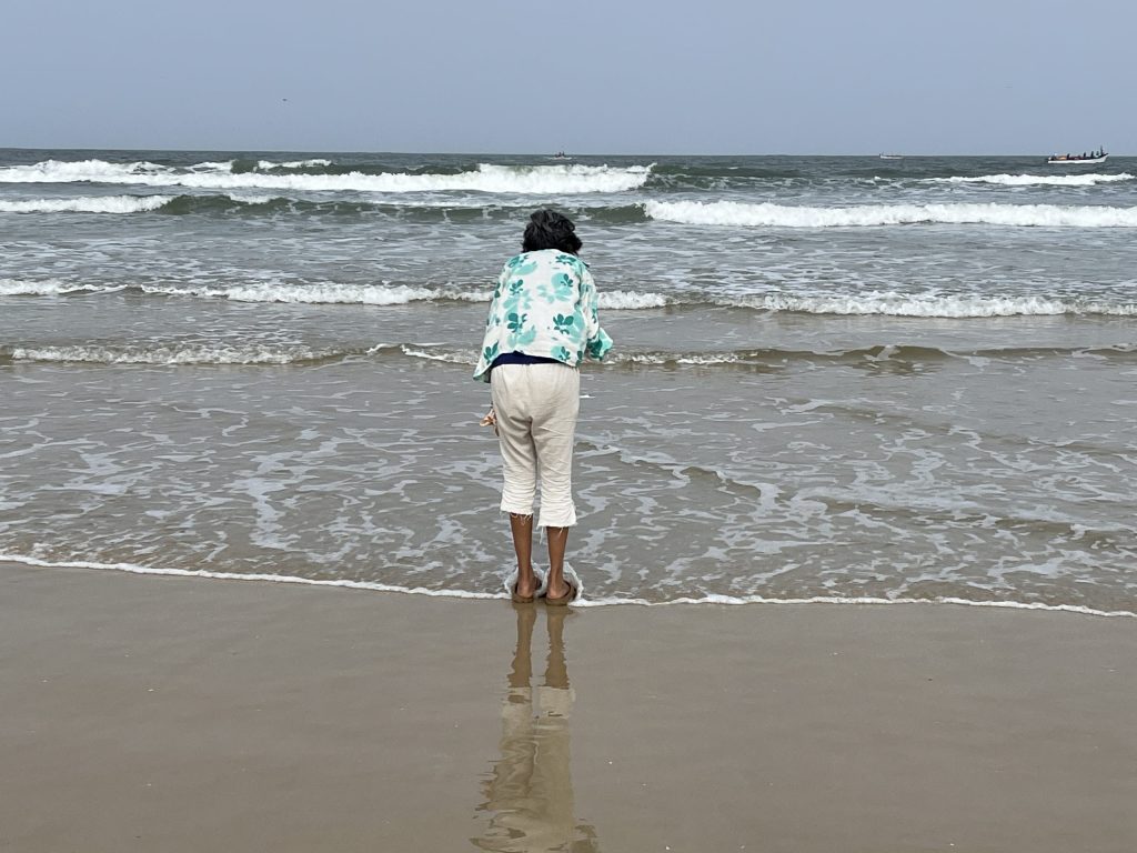 Mental health through slow living - woman practicing mindful presence at Goa beach