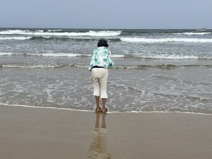 Mental health through slow living - woman practicing mindful presence at Goa beach